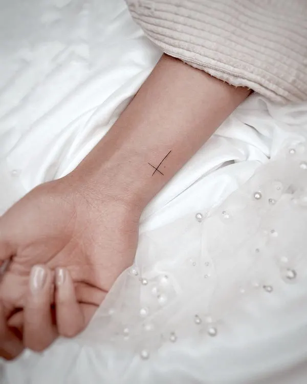Simple cross wrist tattoo by @tinytattoos_feathertouch