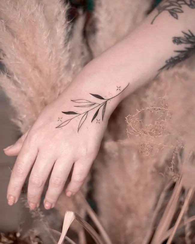 Black and white vine tattoo on the wrist by @pavlenko.ink