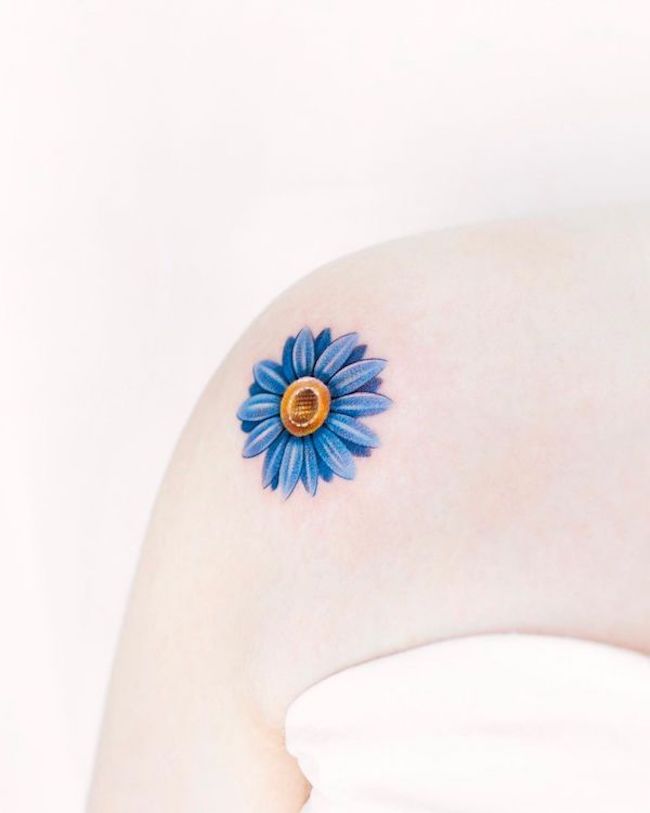 Blue daisy shoulder tattoo by @foret_tattoo