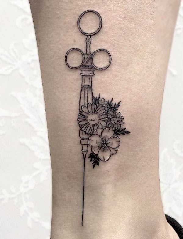 Floral syringe tattoo by @backtobasicstattoo