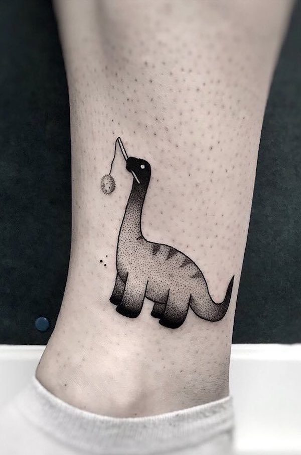 A fun gradient dinosaur ankle tattoo by @clinktattooart