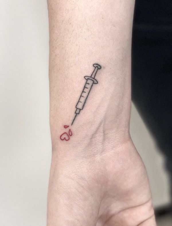 Syringe and heart tattoo by @s4r4_tattoo