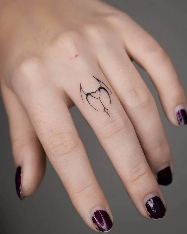 Small devil and angel finger tattoo by @nurai.tattoo