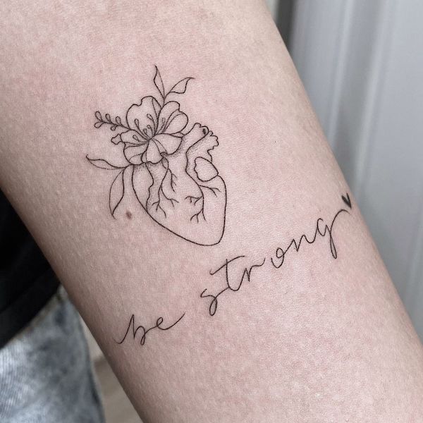 With pain comes strength  quote tattoo on girls ribcage