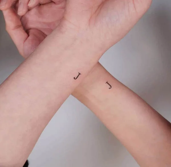 A pair of J initial tattoos by @handitrip