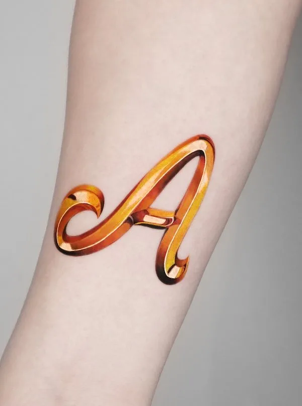 Golden letter A tattoo by @jooa_tattoo
