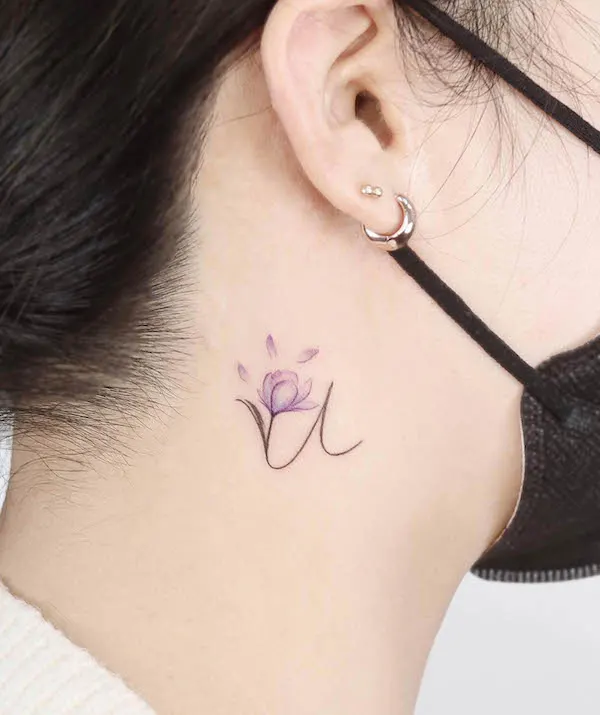 Small letter U behind the ear by @noul_tattoo