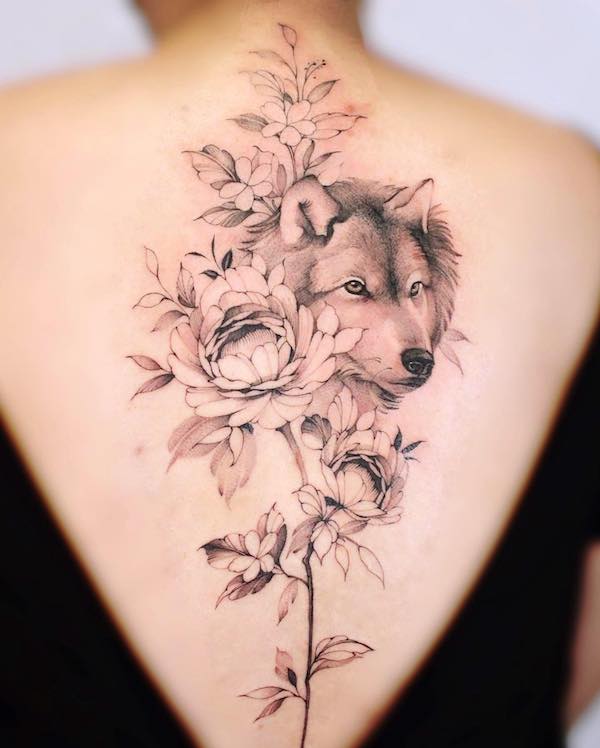 Floral wolf spine tattoo by @baronarttattoo