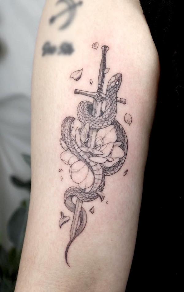 Snake and sword back of the arm tattoo by @choseung.tat