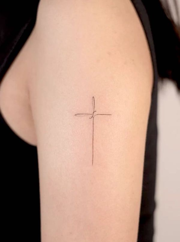 Simple cross outer arm tattoo by @handitrip