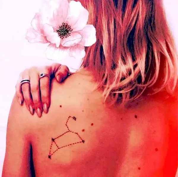 A sleek constellation tattoo on the back by @notjustisabella