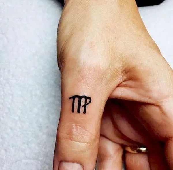 A tiny Virgo finger tattoo by @topp_tattoo