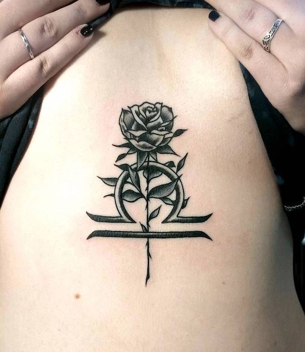 An elegant blackwork Libra rose tattoo by @chris_de_armas