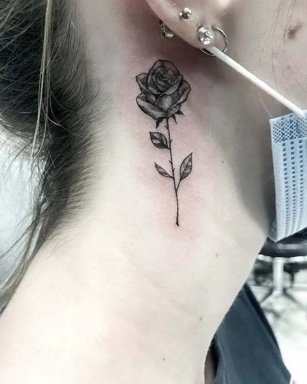 Black rose tattoo on the side of neck by @thierde