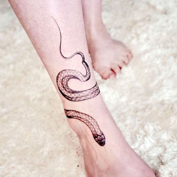 Elegant snake tattoo around the ankle by @jay_tattooist