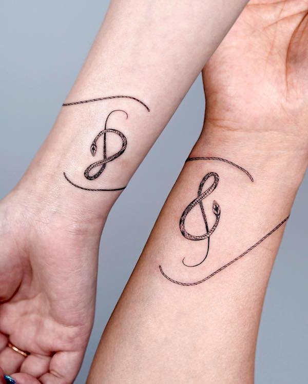 Matching snake music tattoo by @bium_tattoo