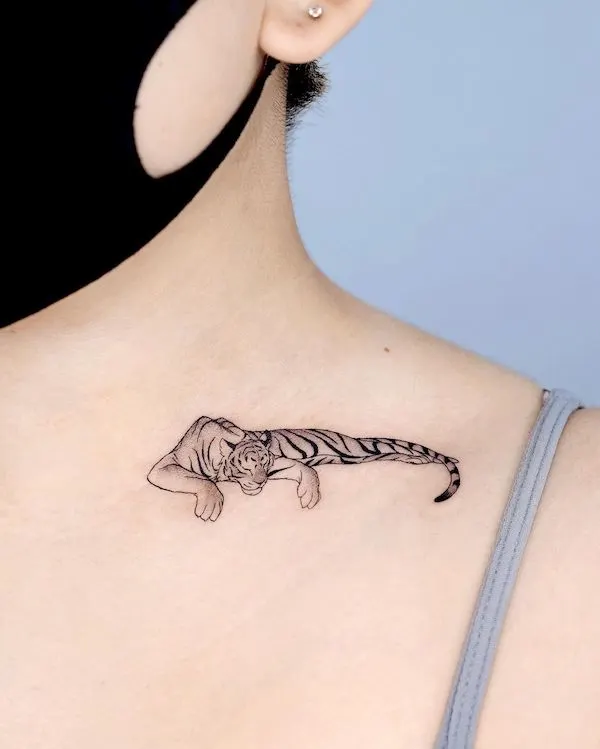Resting tiger on the collarbone by @bium_tattoo