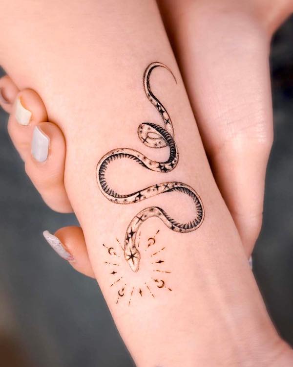 Tiny sparkling snake forearm tattoo by @norangtattoo