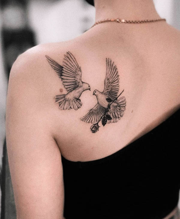A pair of doves on the back by @vic.ink_