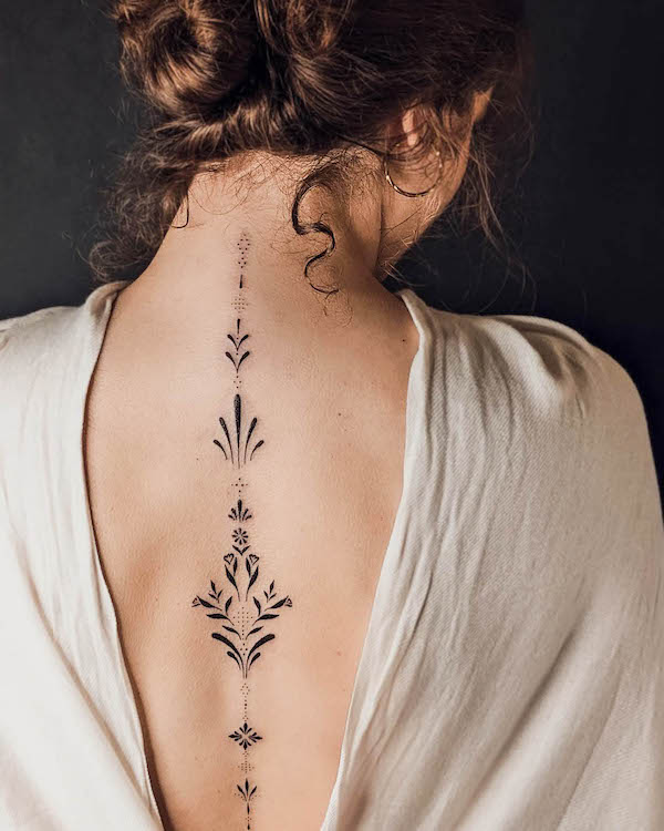 Elegant ornamental spine tattoo by @bibi.lea_.tattoo