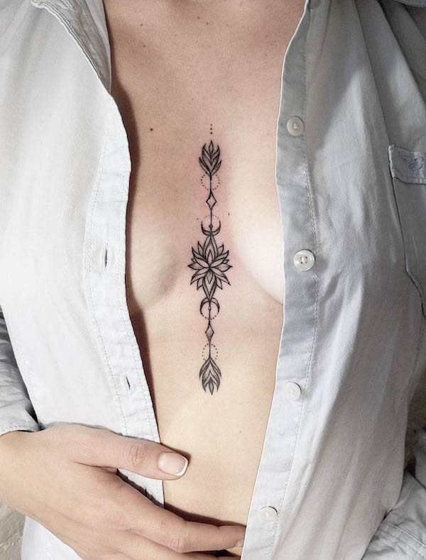 Ornamental tattoo between boobs by @dasha_sumtattoo