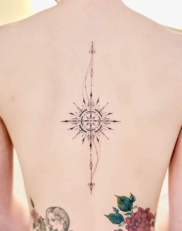 Ornamental tattoo on the back center by @easy.tatt00