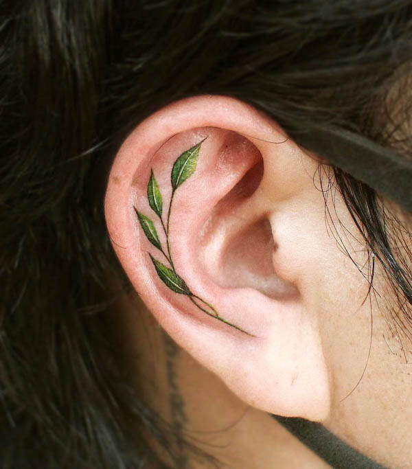 Green leaf behind the ear by @ch.tattoo.ahn