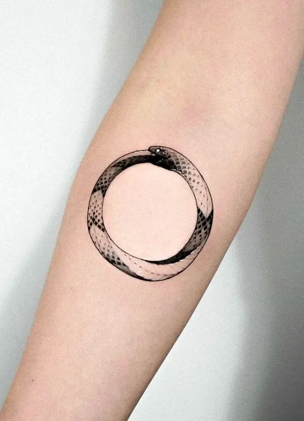 Simple black and grey ouroboros tattoo by @zaeno.tattoo