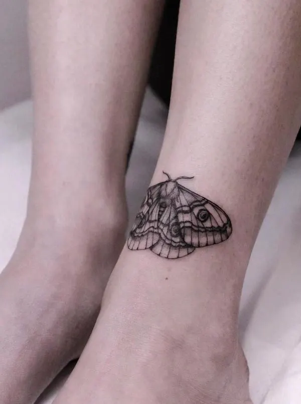Black moth ankle tattoo by @justine.tattoo