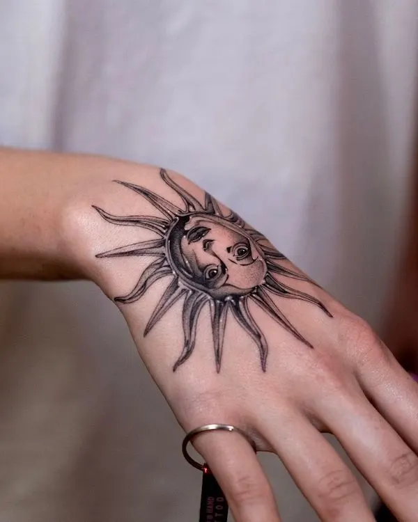 Vintage sun hand tattoo by @gemil_grim