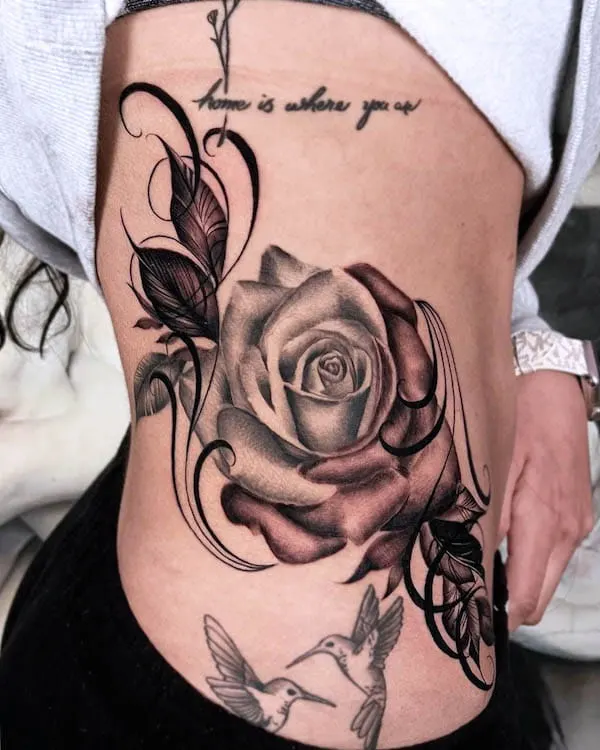 Bold blackwork rose side waist tattoo by @fernxndojrtatts