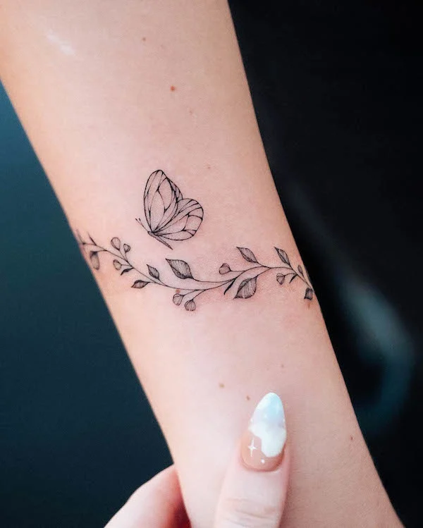 Butterfly floral bracelet tattoo by @bunami.ink
