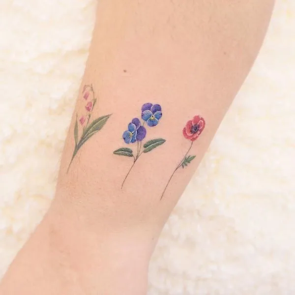 Cute flowers around the wrist by @siyeon_tattoo