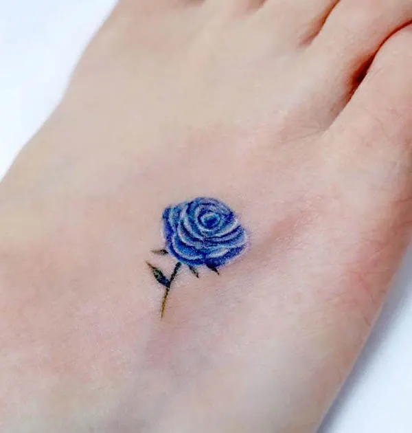 Small blue rose foot tattoo by @sinbar_tattoo