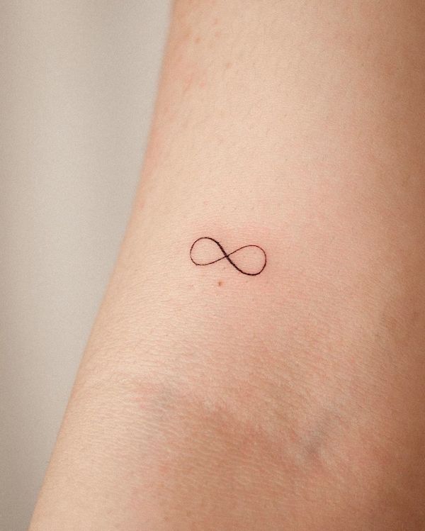 Tiny infinity arm tattoo by @orma_tattoo