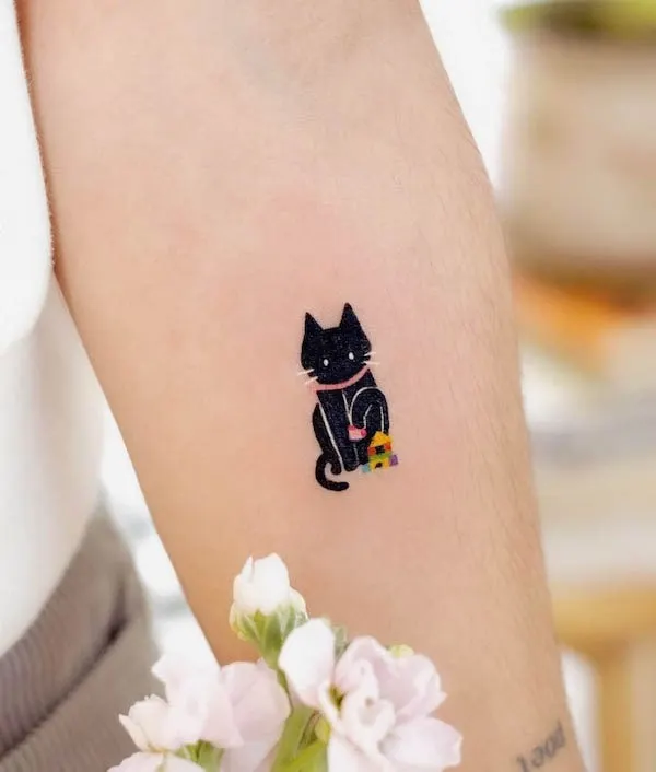 Cute small black cat forearm tattoo by @ovenlee.tattoo