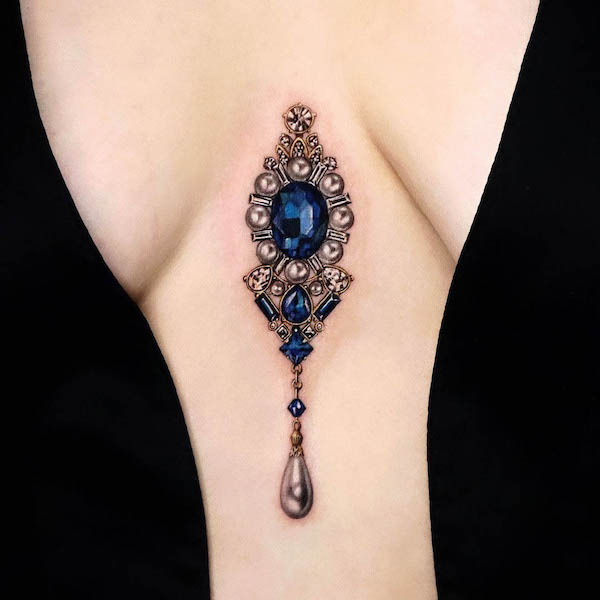 Gemstone pendant between the boobs by @yeriel_tattoo