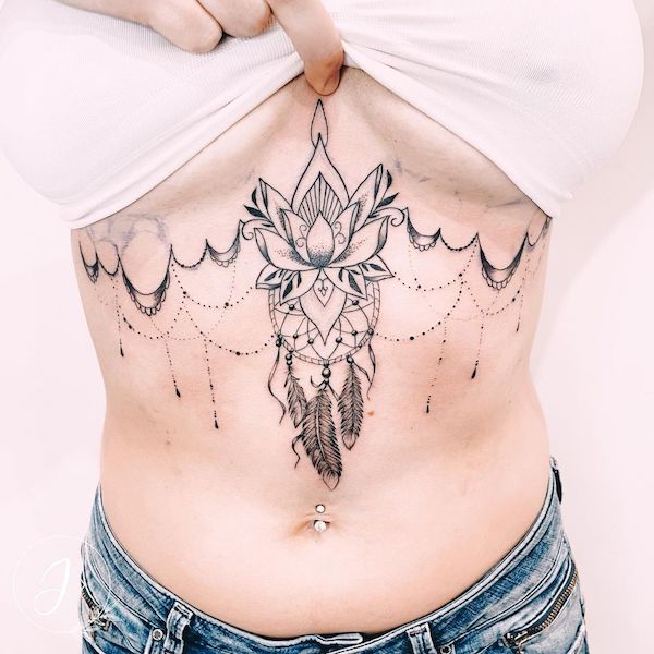 Lotus and dreamcatcher tattoo under boobs by @julinka.tattoo