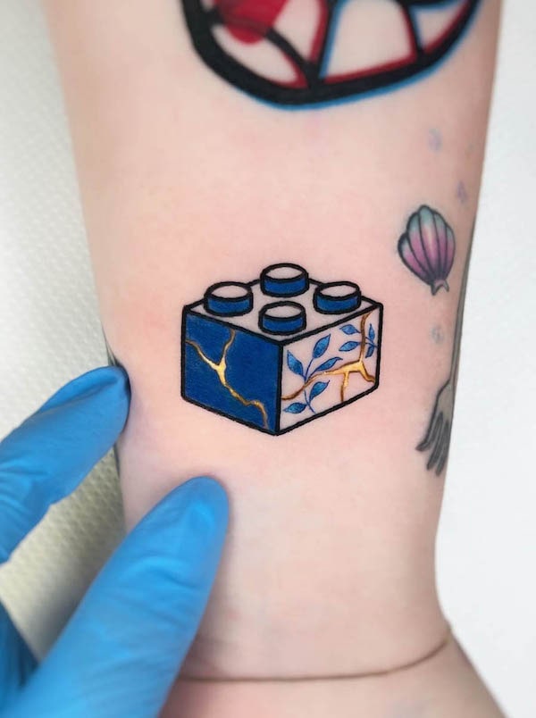 Lego tattoo done on the wrist sketchy style