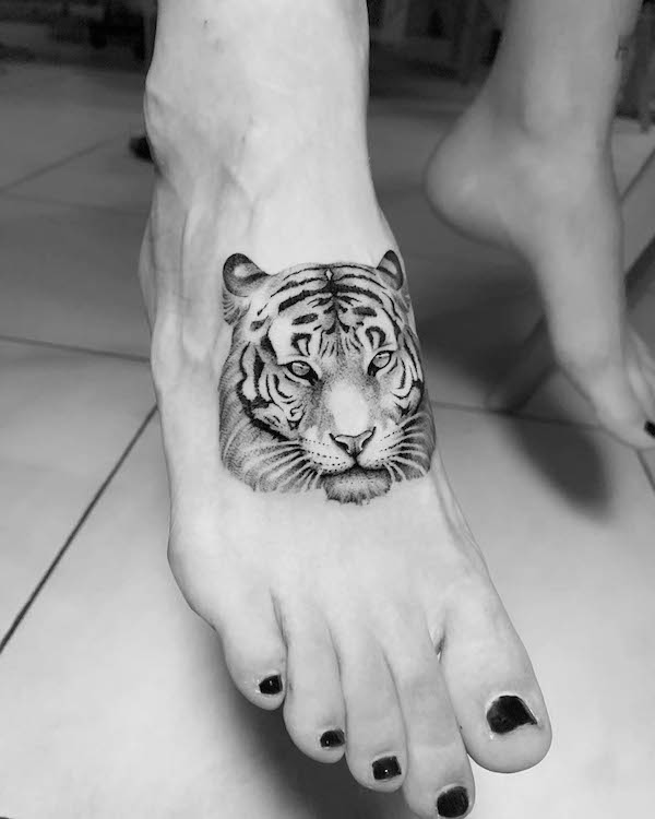 Fierce tiger foot tattoo for women by @sir.edwardtattoo