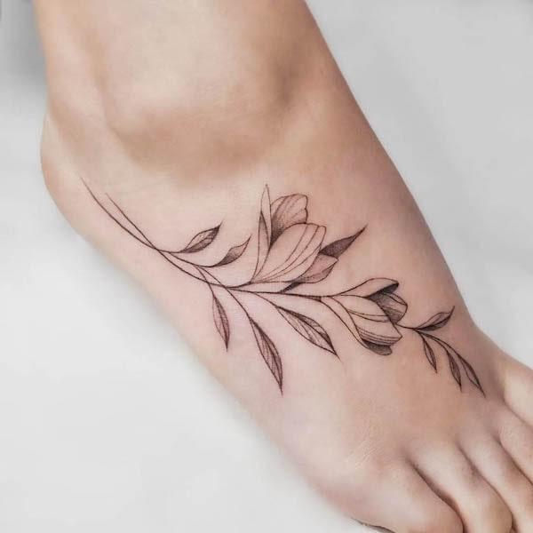 Leaves and branch foot tattoo by @yleniaattard
