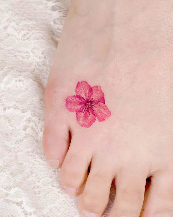 Small cherry blossom foot tattoo by @tilda_tattoo