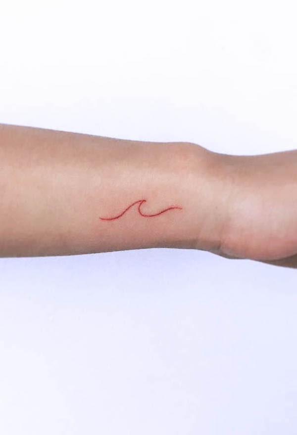Fine line wave tattoo on the forearm