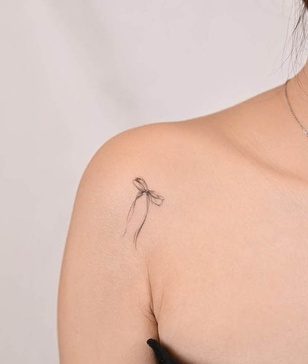 Simple fine line ribbon shoulder tattoo by @tracy_inkso