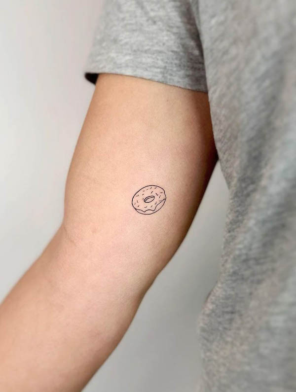 Small simple fine line donut tattoo by @cha.tattoo