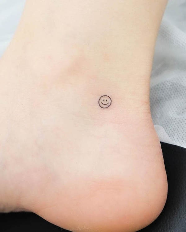 Tiny fine line smiley face ankle tattoo by @wittybutton_tattoo