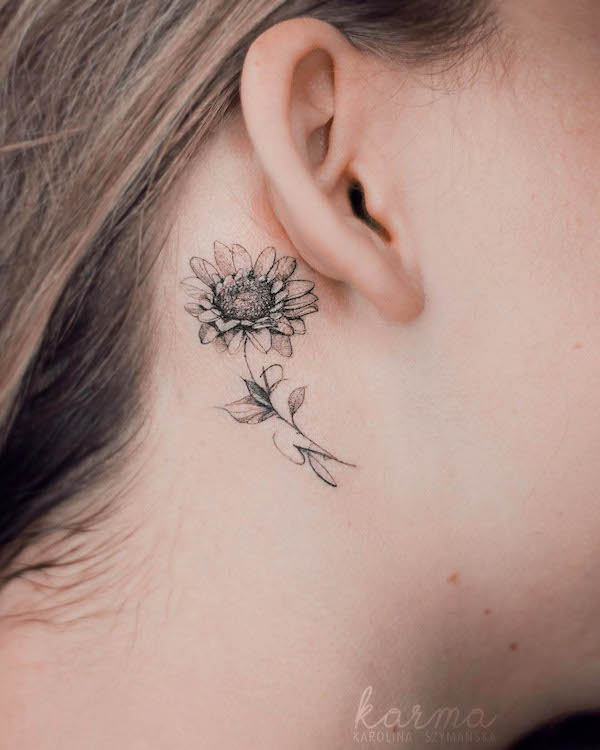 Meaningful sunflower tattoo behind the ear by @karolinaszymanska_tattoo