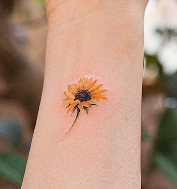 Small sunflower on the wrist by @inkflow_franky