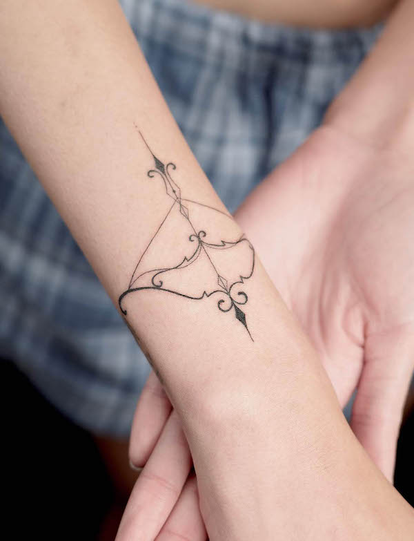 Feminine bow and arrow wrist tattoo by @takeiteasyluv