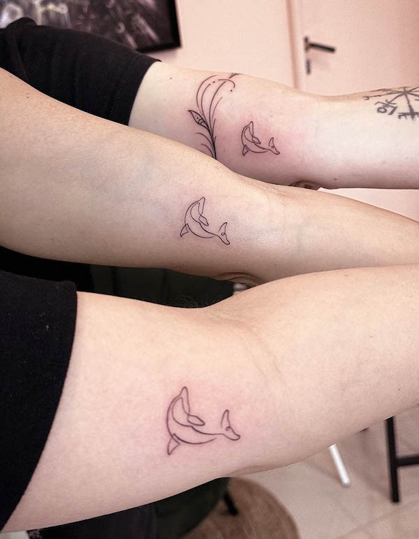 Matching one-line dolphin tattoos by @rekabittencourt